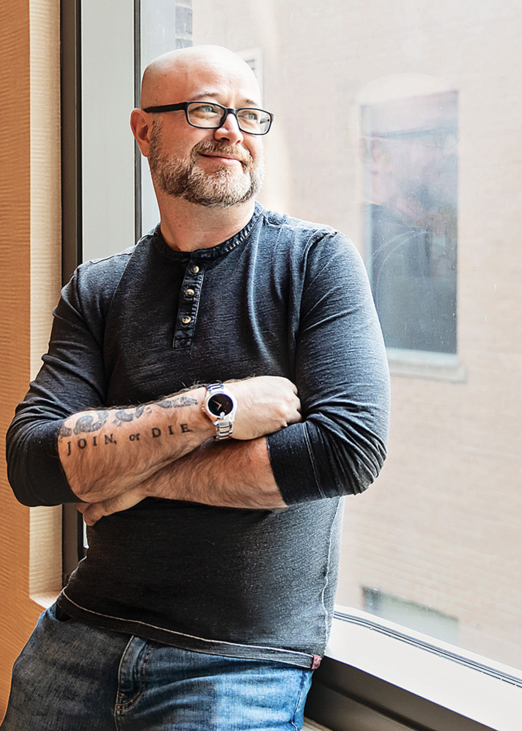 Ron Shaw standing near a window.